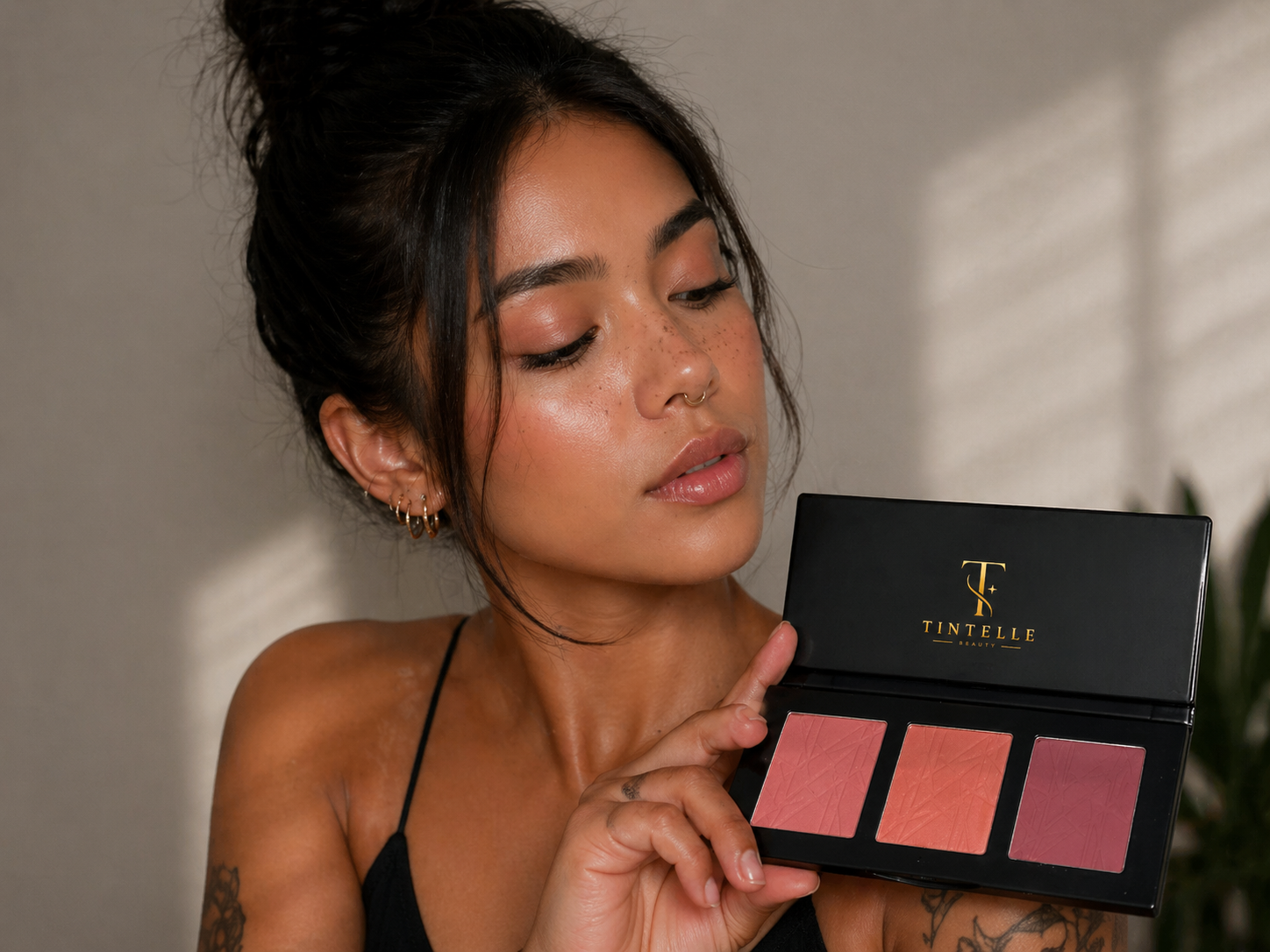 Woman holding a makeup palette with TINTELLE branding